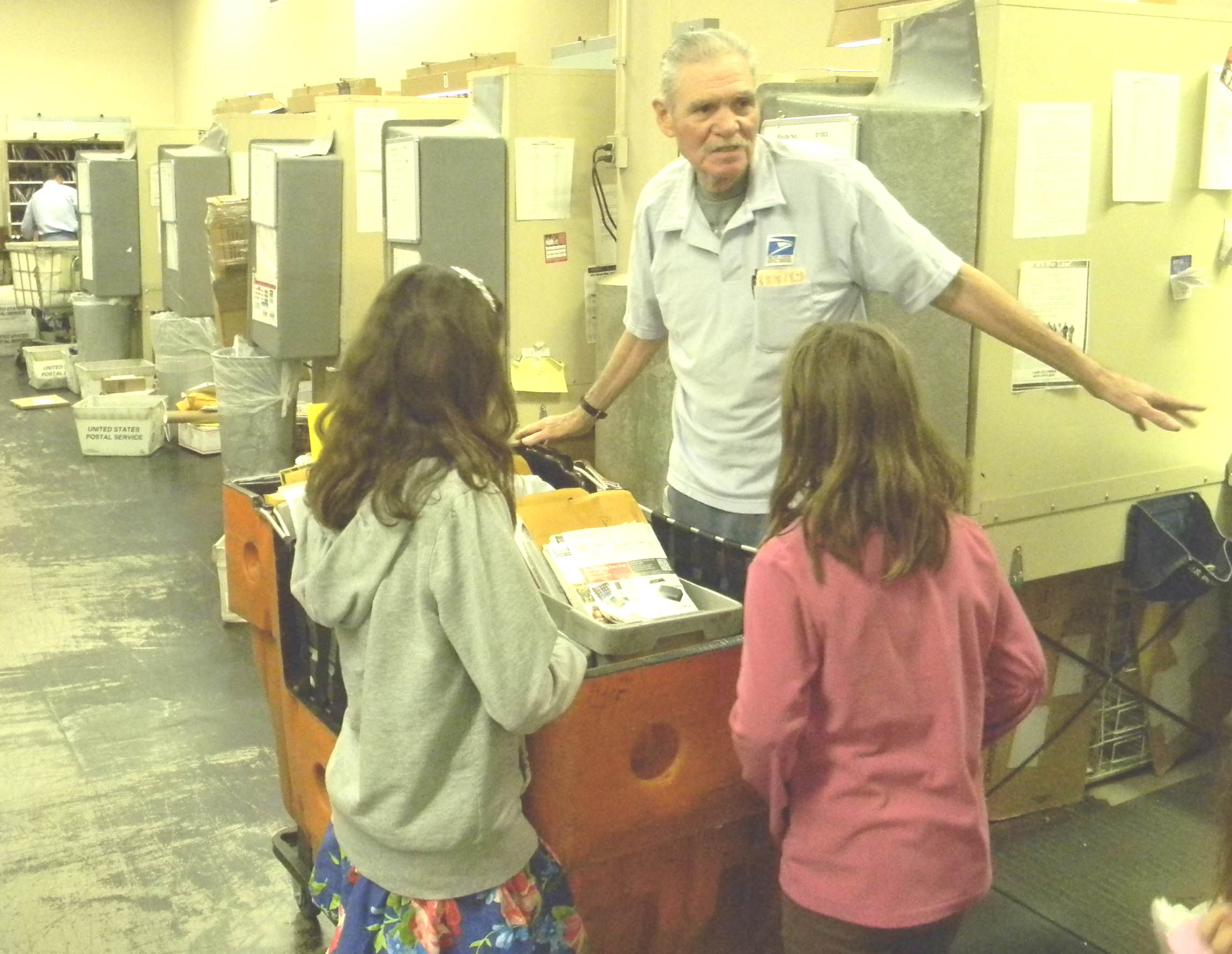 Donna Beth Weilenman/Staff RAYMOND PEREZ shows his granddaughters Synoma, 7, right, and Brianna, 9, the letter sorting operation at Benicia Post Office.