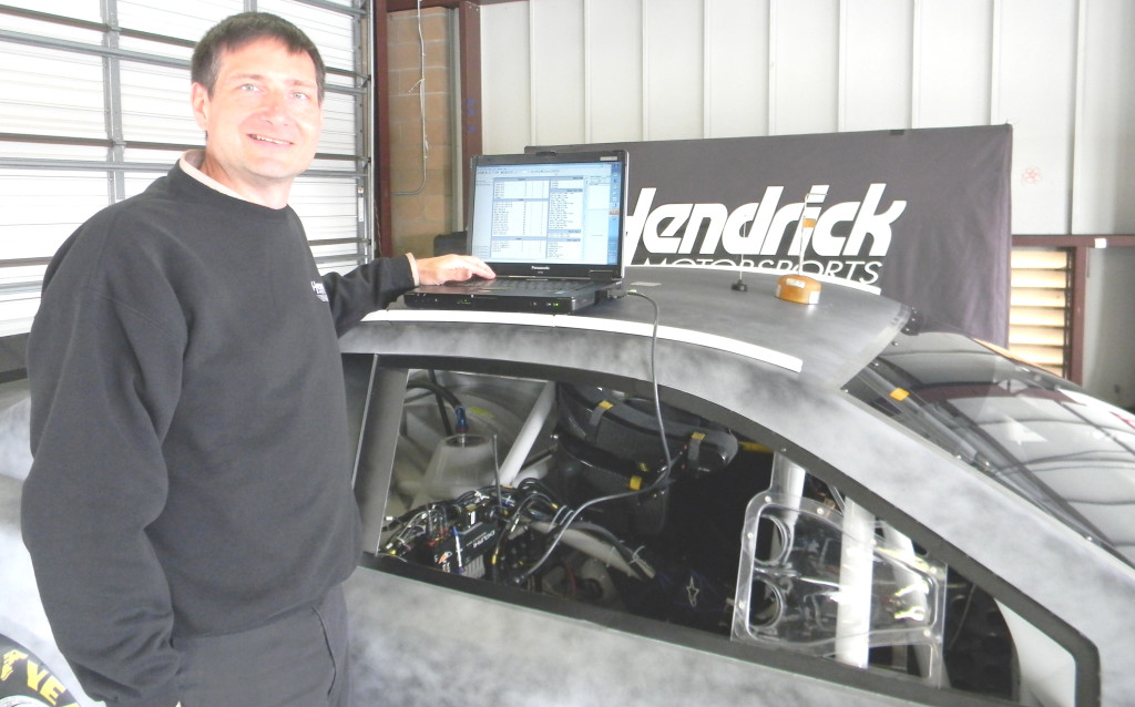 NO NEED TO LOOK UNDER THE HOOD: Dr. H.A. Mergen plugs into a test car to measure data on wind, wheel force and other factors in a garage at Sonoma Raceway last month. Donna Beth Weilenman/Staff   