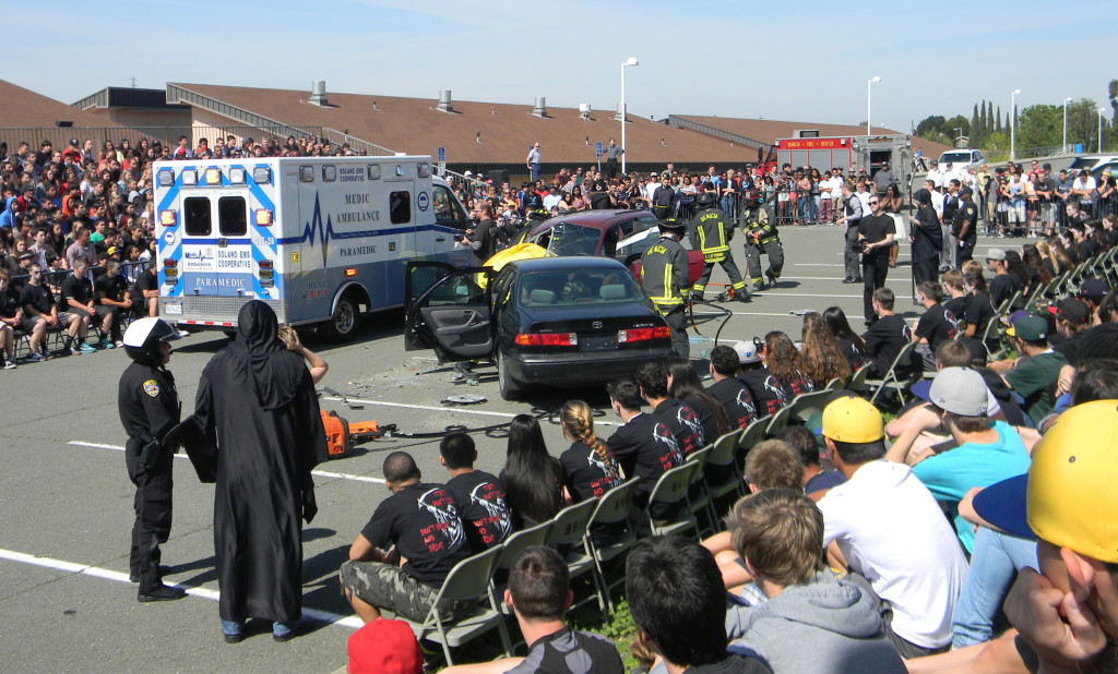 STUDENTS from Benicia and Liberty High schools watch as fellow students portray a fatal alcohol-related collision during Tuesday's "Every 15 Minutes" program.
