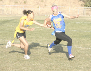 GOLD DEFENDER Karis Wright (left) catches Blue running back Alex Wardlow during Benicia High’s annual Powderpuff football game Friday night at Drolette Stadium.