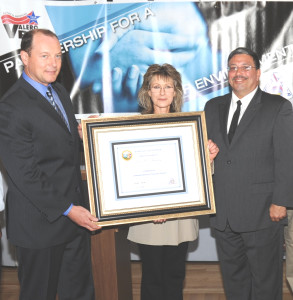 VALERO REFINERY Manager John Hill, left, accepts the VPP certificiate from Cal/OSHA’s Vicky Heza; at right is Ric Irizarry, a member of Valero’s Safety Team. Courtesy photo