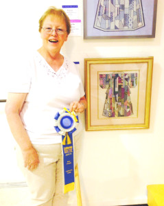 BENICIAN MARY FRANCES KELLY-POH poses with her first place ribbon for needlepoint work at the California State Fair. She won a needlepoint first place this year at the county fair, too. Courtesy photo