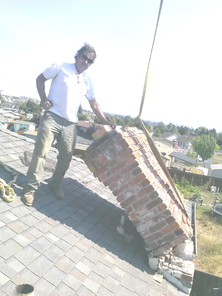 Phil Joy’s FIRST of many repairs after the Aug. 24 earthquake — removing a broken chimney from one of his rental houses in American Canyon. Leo Vargas photo 