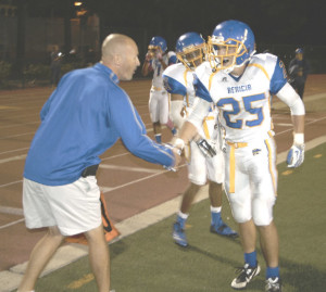 ALEX OSTERHOLT (25) gets congratulated by head coach Craig Holden after running for a 44-yard touchdown against Vallejo on Friday.