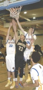BENICIA’S Jack MacDowell (32) and Brandon Barrett (24) squeeze Concord’s Dru Solis for a loose ball.