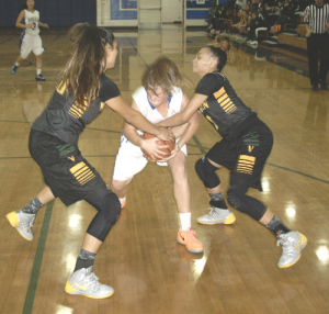 BENICIA’S ELIZABETH SWEENEY (center) wrestles Vanden’s Brittney Livingston (left) and Kiana Moore for a loose ball in the SCAC opener for both teams Friday night.