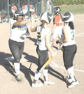 CYDNEY HAMPTON (left) gets congratulated by SPSV teammates Chelsea Mari (2) and Marisa Avalos after scoring a run against St. Mary’s.