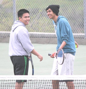 BENICIA TEAMMATES Andrew Butawan (left) and Emad Abdul-Wajid share a lighter moment during their No. 1 doubles match at Bethel High School.