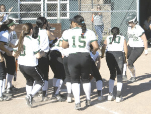 JAYDEE BOURSAW (far right) gets greeted at home plate by her Lady Bruin teammates after clubbing a home run against Pinole Valley.