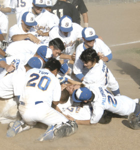 THE PANTHERS mob teammate Justin Badger at home plate after he scored the winning run against American Canyon.