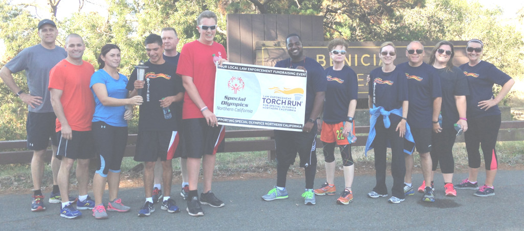 BENICIA POLICE CHIEF Erik Upson (fifth from left) handed the Special Olympics torch to Vallejo police Capt. Lee Horton at the Benicia State Recreational Area on Wednesday morning. Donna Beth Weilenman/Staff