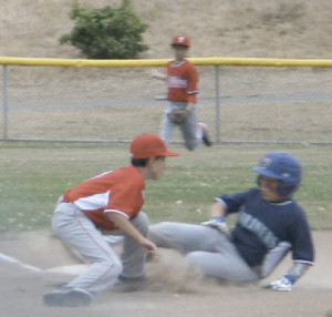 CADE ZIELSTORFF of the Mariners slides into third just ahead of the tag by Phillies third baseman Bryce Colaizzi.