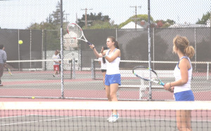 MARIAH MCNALLY (left) returns a shot against Vallejo as Benicia teammate Katie Steinman looks on.