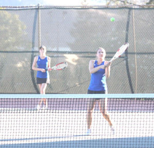 MARIAH MCNALLY (right) of Benicia rips a shot as doubles teammate Katie Voss looks on.