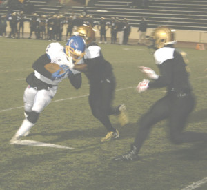 BENICIA HIGH’S Cavon Etter (left) tries to break away from Bethel linebacker Kalen Morris. Etter ran for three touchdowns in Benicia’s 69-38 victory over the Jaguars.