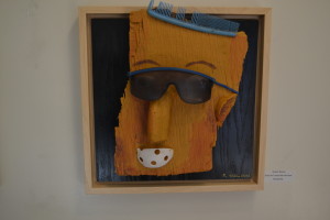 "Since His Hair Turned Blue," by Gallery 621 artist Robert Nelson, is a 12 X 12-inch reclaimed work featuring recycled materials such as a blue comb, subglasses and a piece of a whiffleball over a painted backdrop. Nelson's work is one of many featured in the gallery's new exhibition "Perfect Square," which will have its opening reception tomorrow. (Photo by Nick Sestanovich)