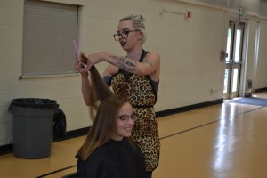 Terra Allen cuts sophomore Lily Chase's hair at Benicia High School's Make the Cut event, in which students donated 8 inches of hair to Pantene, which then makes the hair into a wig for cancer victims. Chase's mother Theresa was diagnosed with ovarian cancer and was the first to have her hair cut that day. (Photo by Nick Sestanovich)